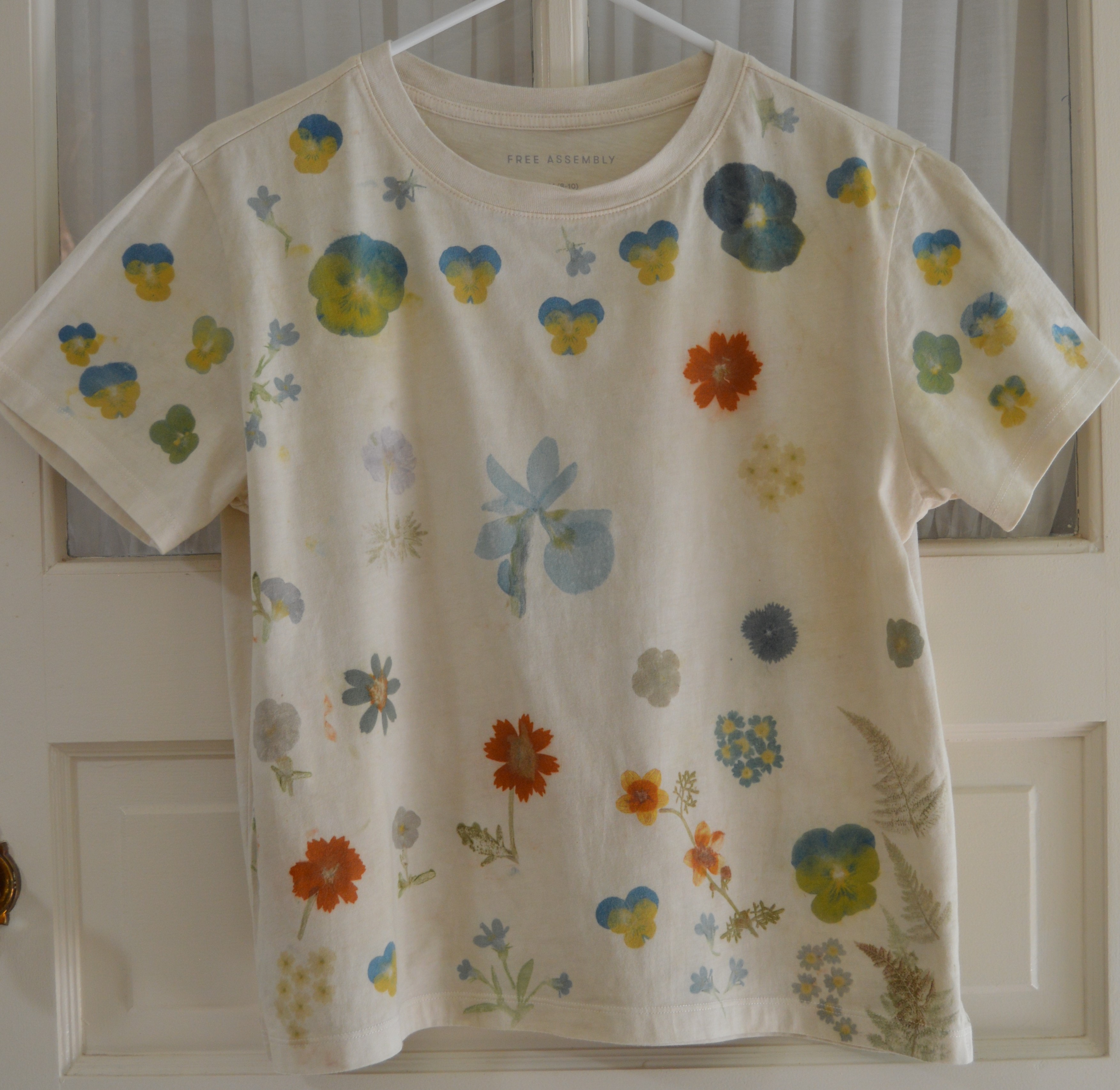 Front of a cream combed-cotton T-shirt pounded with colorful spring flora motifs